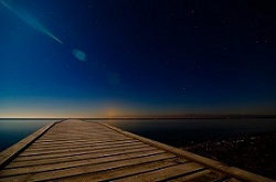 青い夜明けの光と桟橋の画像