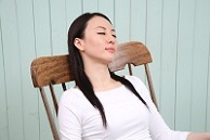 /目を閉じてくつろぐ女性の写真