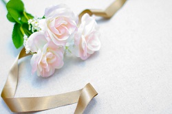 ピンクサテンのリボンとバラの花の写真