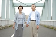 手をつないで立つ夫妻の写真